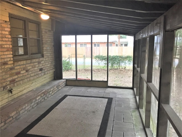 unfurnished sunroom featuring vaulted ceiling