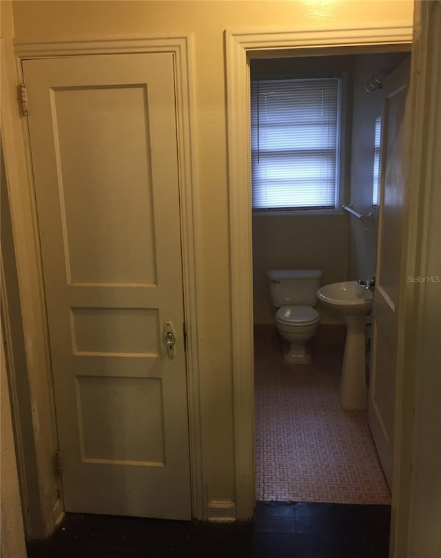 bathroom featuring toilet, tile patterned floors, and sink