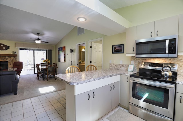 kitchen with visible vents, lofted ceiling, a peninsula, stainless steel appliances, and light countertops