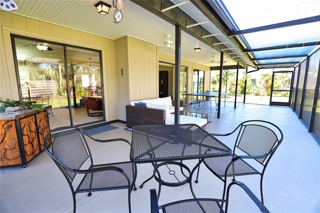 view of patio / terrace with glass enclosure, ceiling fan, outdoor lounge area, and outdoor dining space