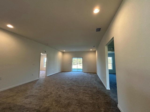 unfurnished room with dark carpet