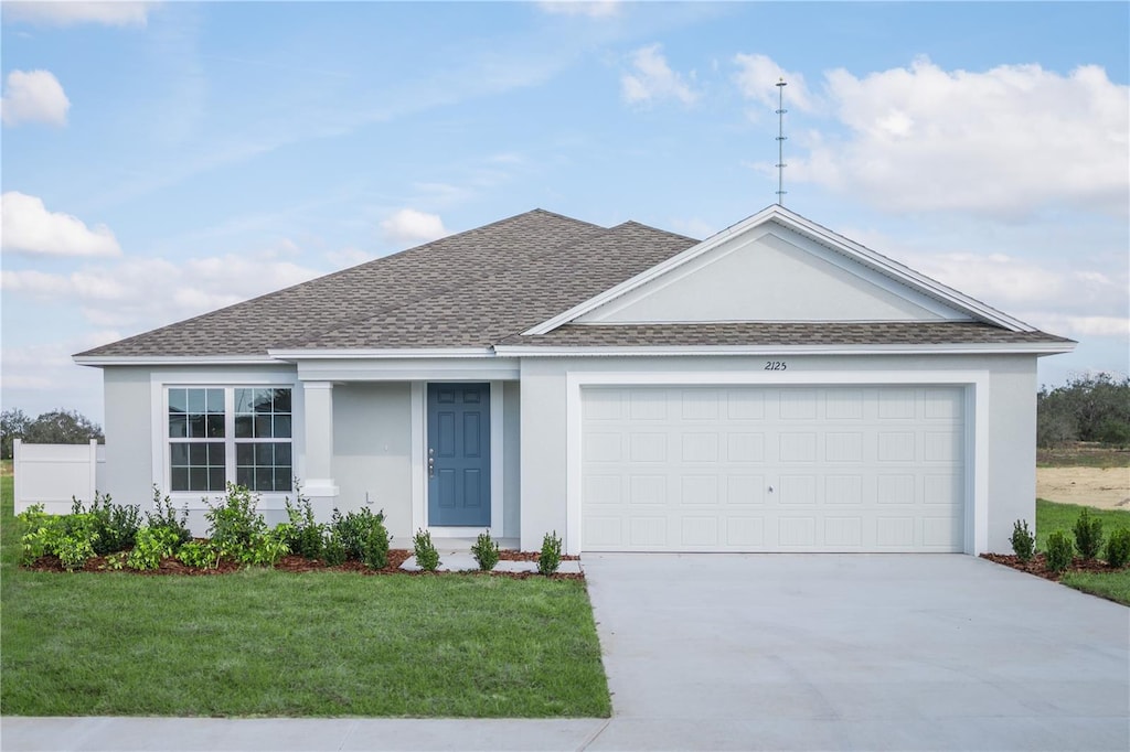 ranch-style house featuring a shingled roof, concrete driveway, an attached garage, stucco siding, and a front yard