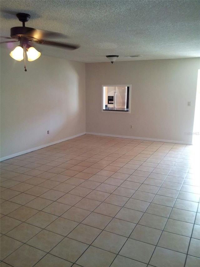 tiled spare room with ceiling fan and a textured ceiling