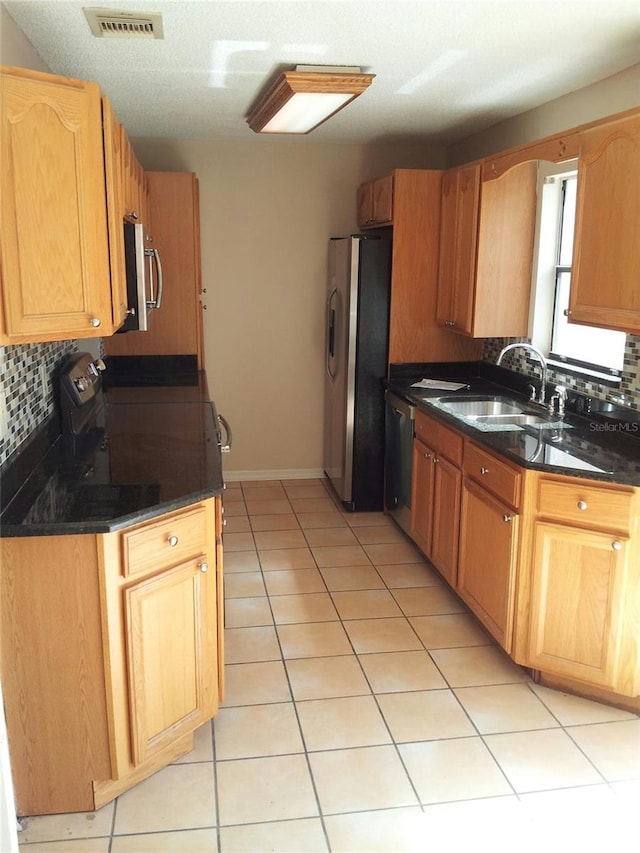 kitchen with decorative backsplash, sink, light tile patterned floors, and stainless steel appliances