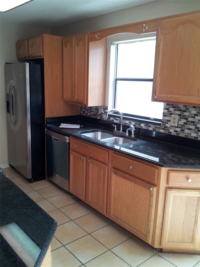 kitchen featuring backsplash, sink, light tile patterned flooring, and stainless steel appliances