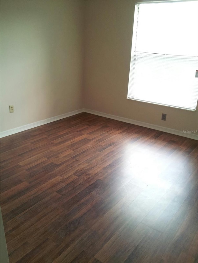 unfurnished room with dark hardwood / wood-style flooring