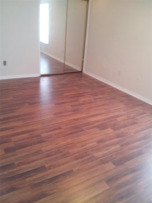 empty room with dark wood-type flooring