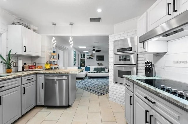 kitchen with decorative backsplash, light stone countertops, stainless steel appliances, ceiling fan, and white cabinets