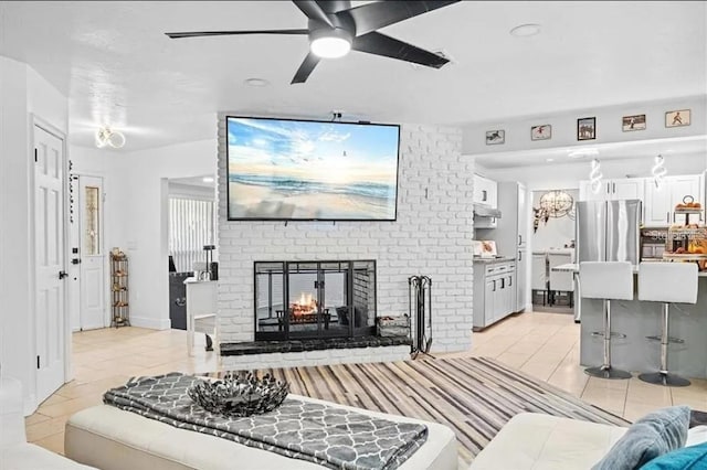 tiled living room with ceiling fan and a brick fireplace