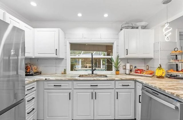 kitchen with sink, hanging light fixtures, stainless steel appliances, tasteful backsplash, and white cabinets