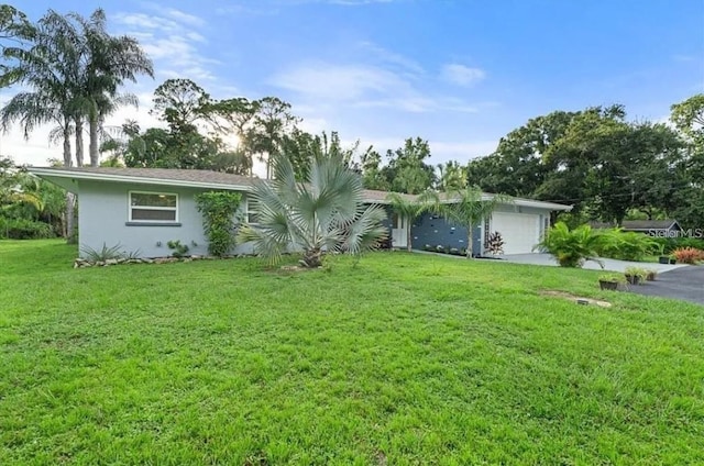 single story home with a garage and a front lawn