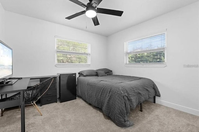 carpeted bedroom with ceiling fan and multiple windows