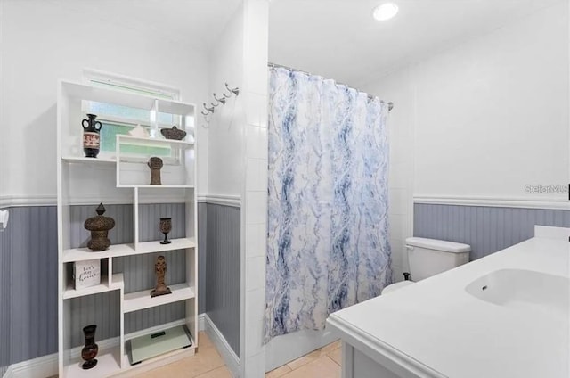 full bathroom featuring shower / bathtub combination with curtain, tile patterned flooring, vanity, and toilet