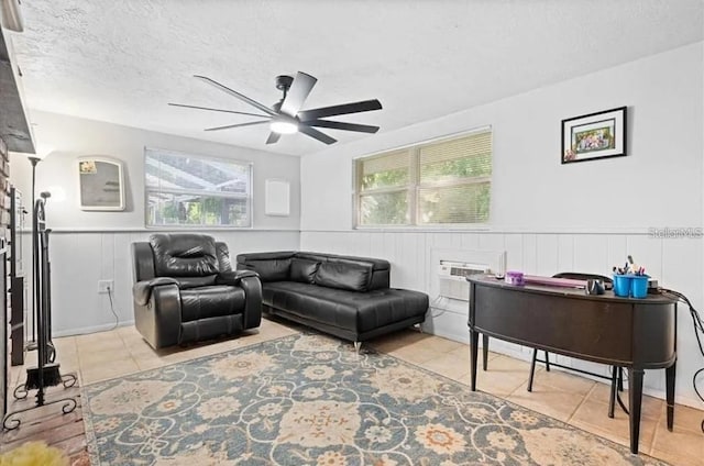 tiled living room with ceiling fan, a textured ceiling, and a wall unit AC