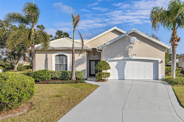 view of front of home with a garage and a front lawn