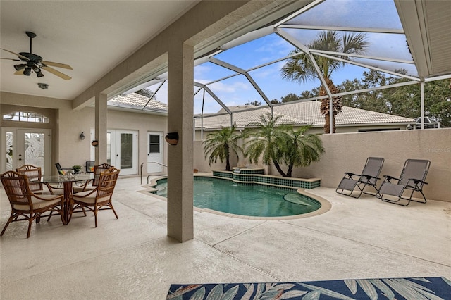 view of swimming pool with ceiling fan, a lanai, french doors, and a patio