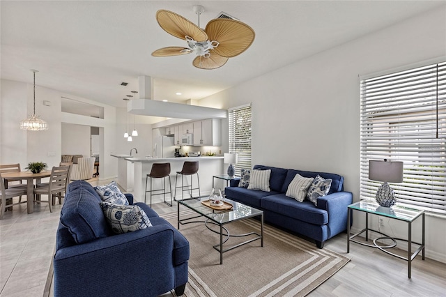 living room with ceiling fan with notable chandelier