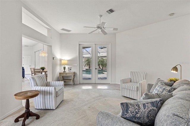 carpeted living room with ceiling fan and french doors