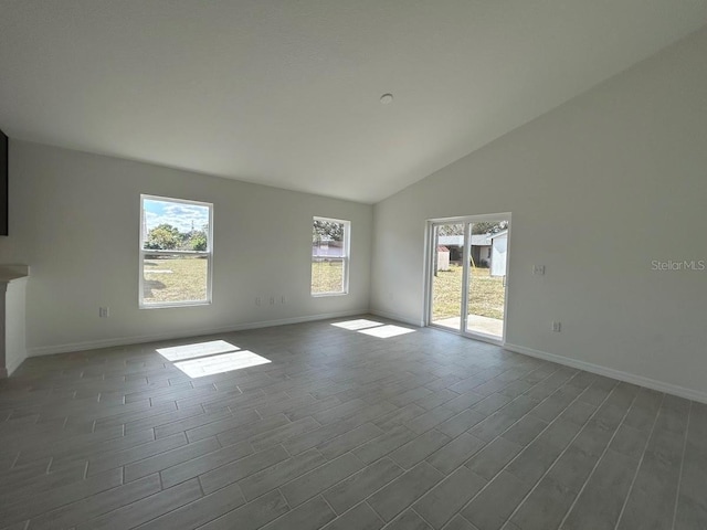 unfurnished room with high vaulted ceiling, dark wood finished floors, and baseboards