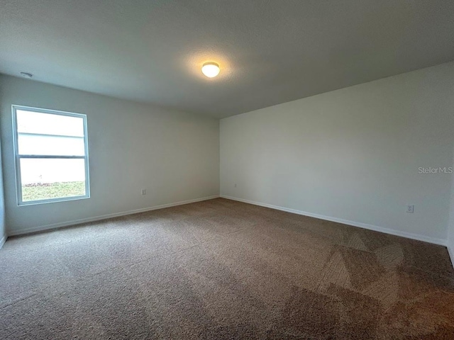 empty room with carpet floors and baseboards