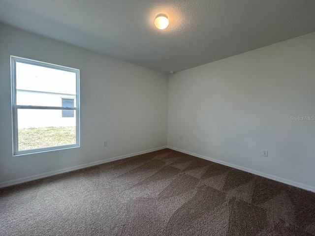 empty room with carpet and baseboards