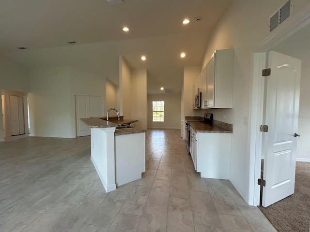 kitchen featuring stainless steel appliances, a sink, visible vents, white cabinetry, and dark stone countertops