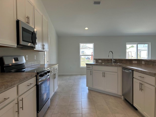 kitchen featuring white cabinetry, visible vents, appliances with stainless steel finishes, and a sink