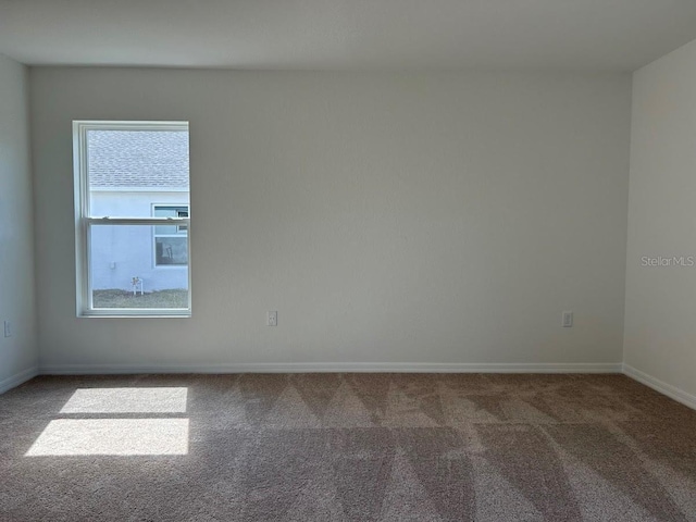 empty room with baseboards and carpet flooring