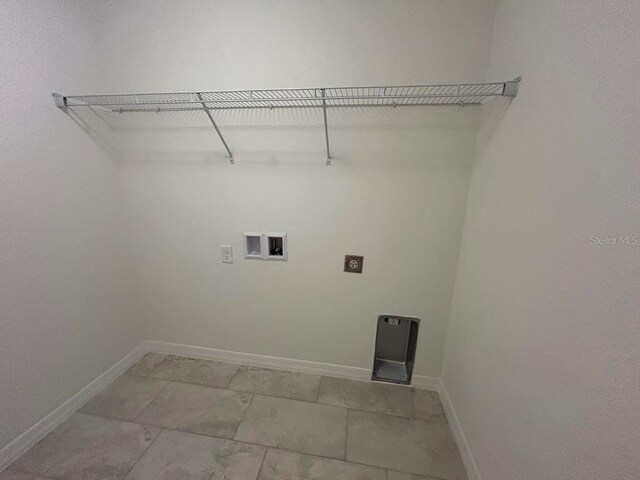 clothes washing area with baseboards, laundry area, hookup for a washing machine, and hookup for an electric dryer