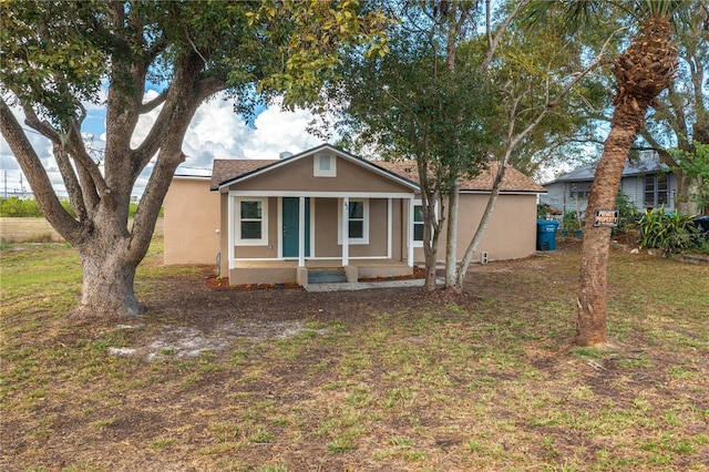 view of front facade featuring covered porch and a front yard