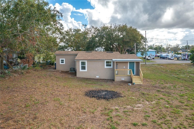 rear view of property with covered porch, a yard, and cooling unit