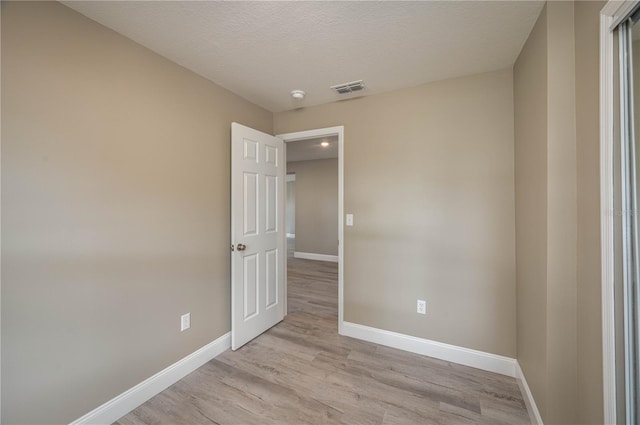 unfurnished bedroom featuring light hardwood / wood-style flooring and a textured ceiling