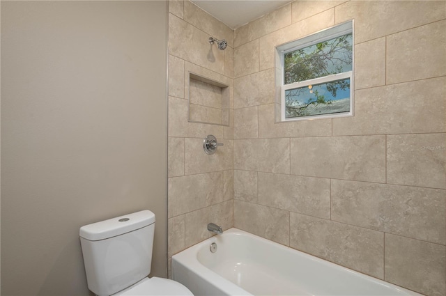 bathroom with tiled shower / bath combo and toilet