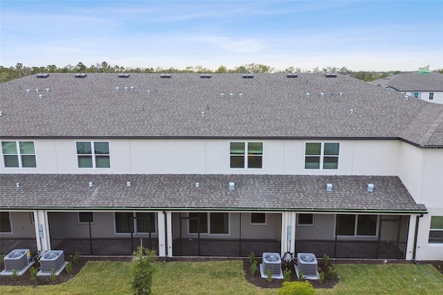 back of property with central air condition unit, a yard, and a sunroom