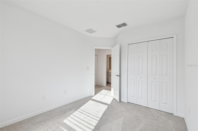 unfurnished bedroom featuring a closet and light carpet