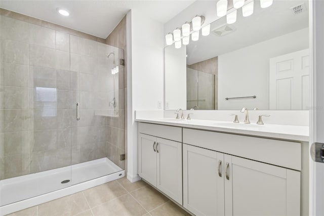 bathroom with an enclosed shower, vanity, and tile patterned flooring