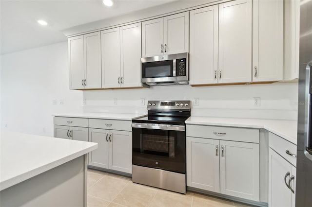 kitchen featuring light tile patterned floors, appliances with stainless steel finishes, and gray cabinets