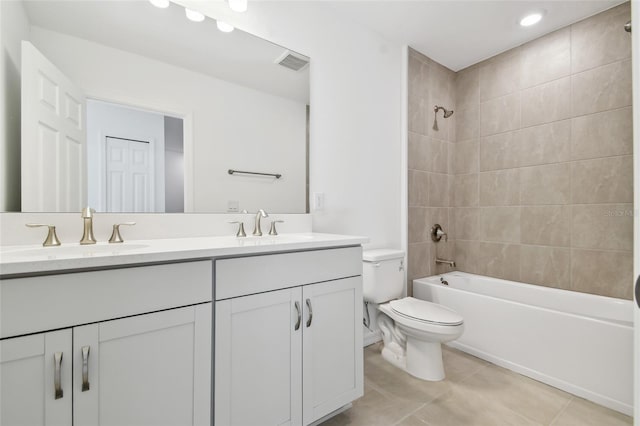 full bathroom with tiled shower / bath combo, vanity, toilet, and tile patterned flooring