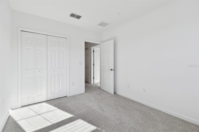 unfurnished bedroom with a closet and light carpet