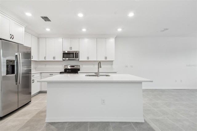 kitchen featuring white cabinets, sink, appliances with stainless steel finishes, and an island with sink