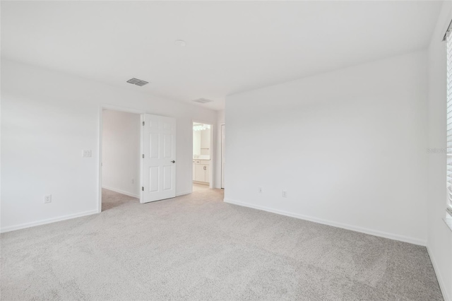 unfurnished room featuring light colored carpet