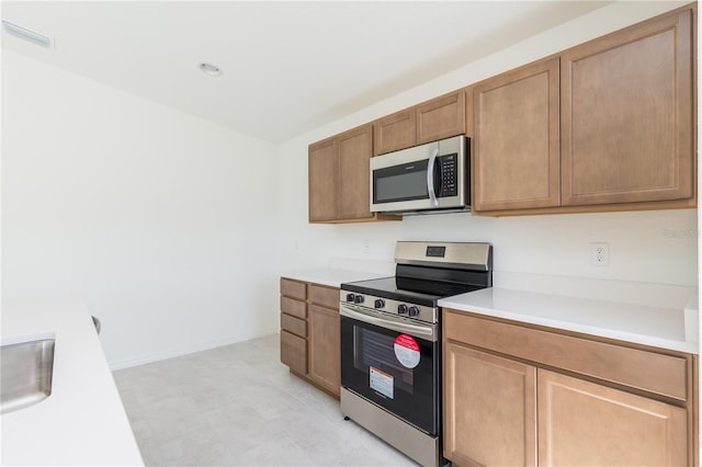 2203 Carson Loop, Lake Wales, FL 33859 - kitchen with brown cabinets, stainless steel appliances, light countertops, visible vents, and a sink