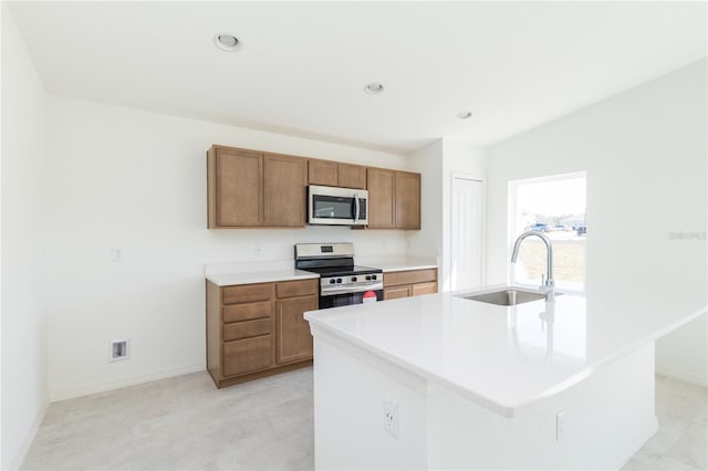 2203 Carson Loop, Lake Wales, FL 33859 - kitchen with stainless steel appliances, a sink, baseboards, brown cabinetry, and light countertops