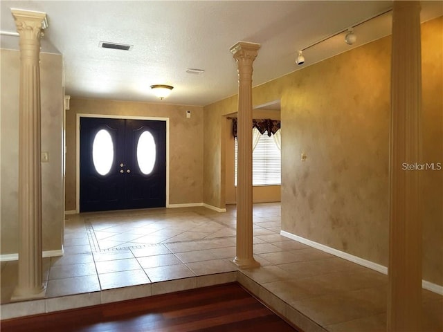 tiled foyer entrance featuring ornate columns