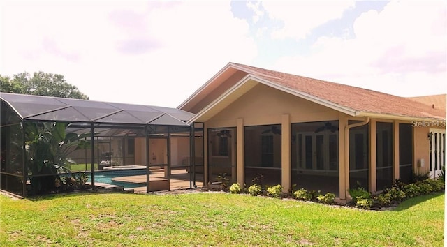 back of property with a lanai and a yard