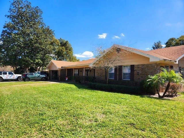 single story home with a front yard and brick siding