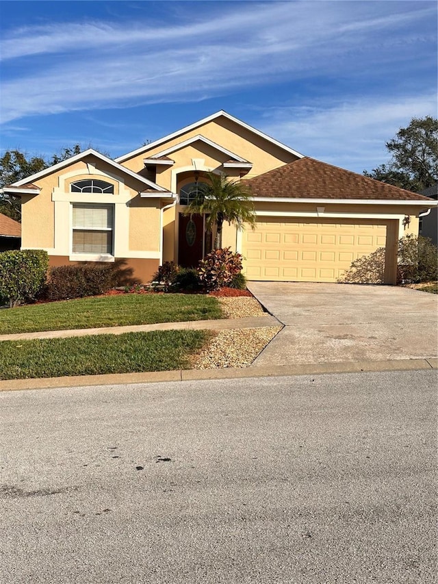 single story home with a front yard and a garage