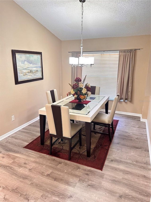 dining room with hardwood / wood-style floors and a textured ceiling