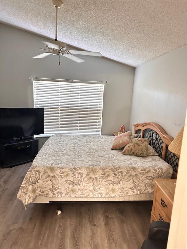 bedroom featuring a textured ceiling, ceiling fan, multiple windows, dark hardwood / wood-style floors, and lofted ceiling