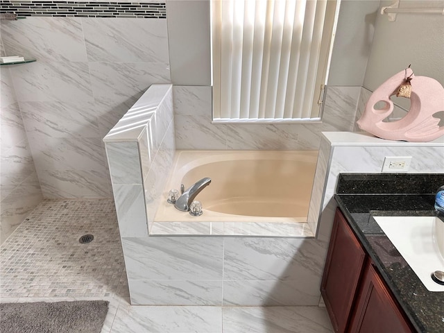 bathroom with vanity and a relaxing tiled tub